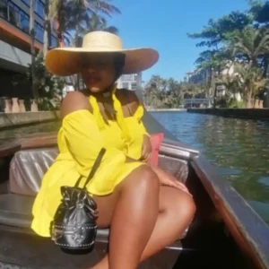 A woman in a yellow dress enjoys a Zulumoon canal ride, showcasing the best boat rides Durban offers.