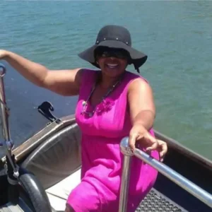 easy-boarding-zulumoon-gondola-durban-boat-cruise A woman in a pink dress boarding a Zulumoon gondola, illustrating how easy and safe it is to ride the canals at the Point Waterfront in Durban.