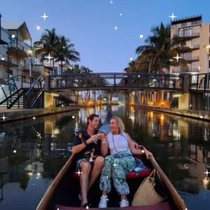 A couple sharing a romantic toast on an evening Zulumoon gondola cruise, a top choice for weekend boat rides in Durban.