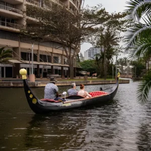 A couple experiences a private gondola boat ride along the scenic waterfront canal.