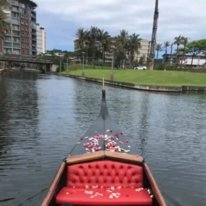 romantic-private-boat-rides-durban A view from inside a private gondola decorated with rose petals, cruising down the scenic waterfront canal.