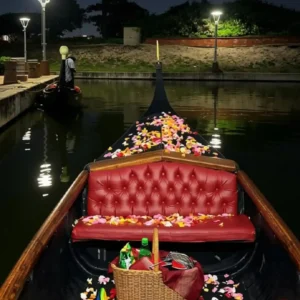 A luxury gondola with red seating and scattered rose petals offers the best romantic picnic date in Durban.